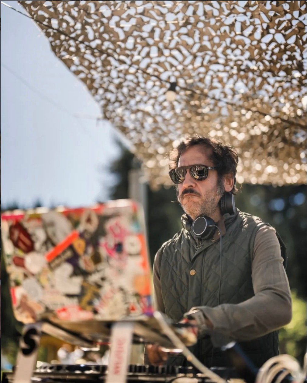 Gordoncho Tellado con auriculares detrás de una computadora al aire libre